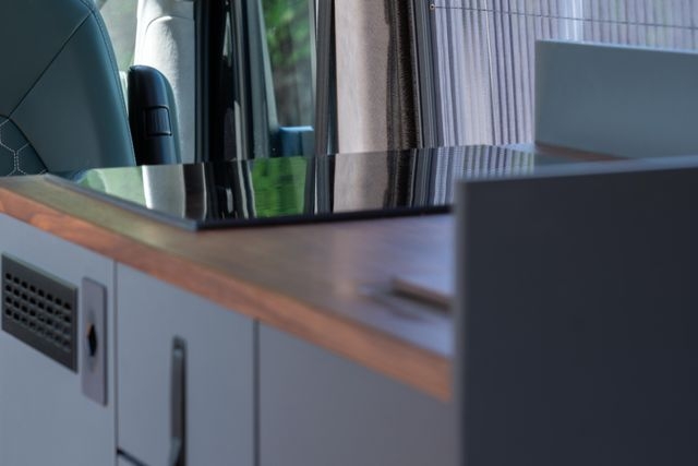 Küche im Camper Van con Cocoon Vans mit zwei Induktionsplatten